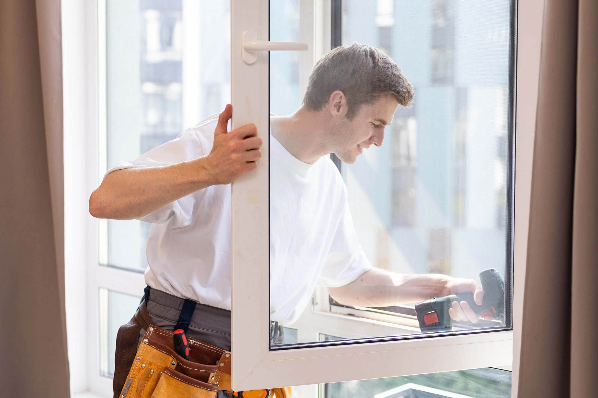 Construction worker installing window in house