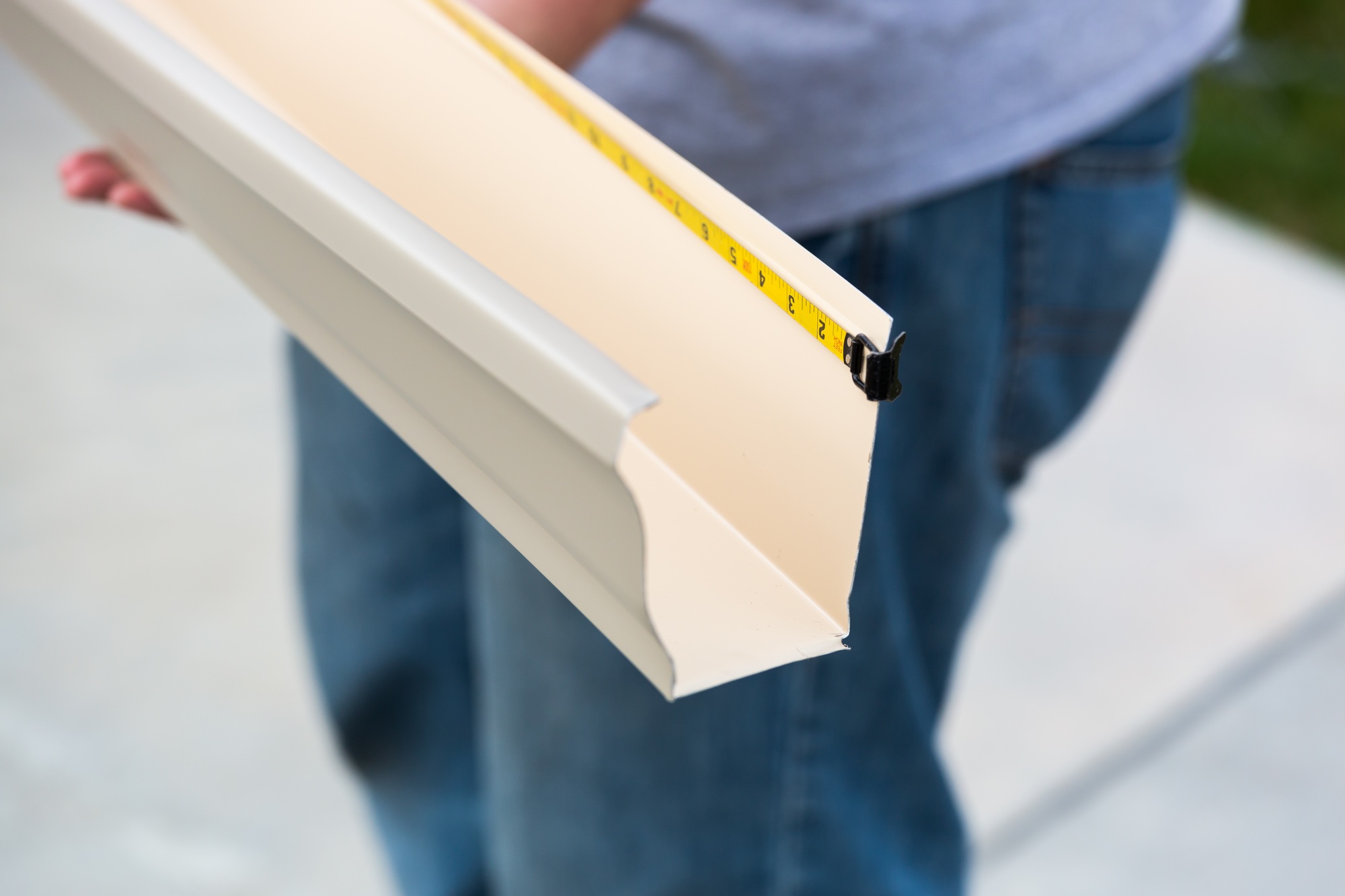 Worker Measuring Rain Gutter Processing Through Seamless Shaping Machine